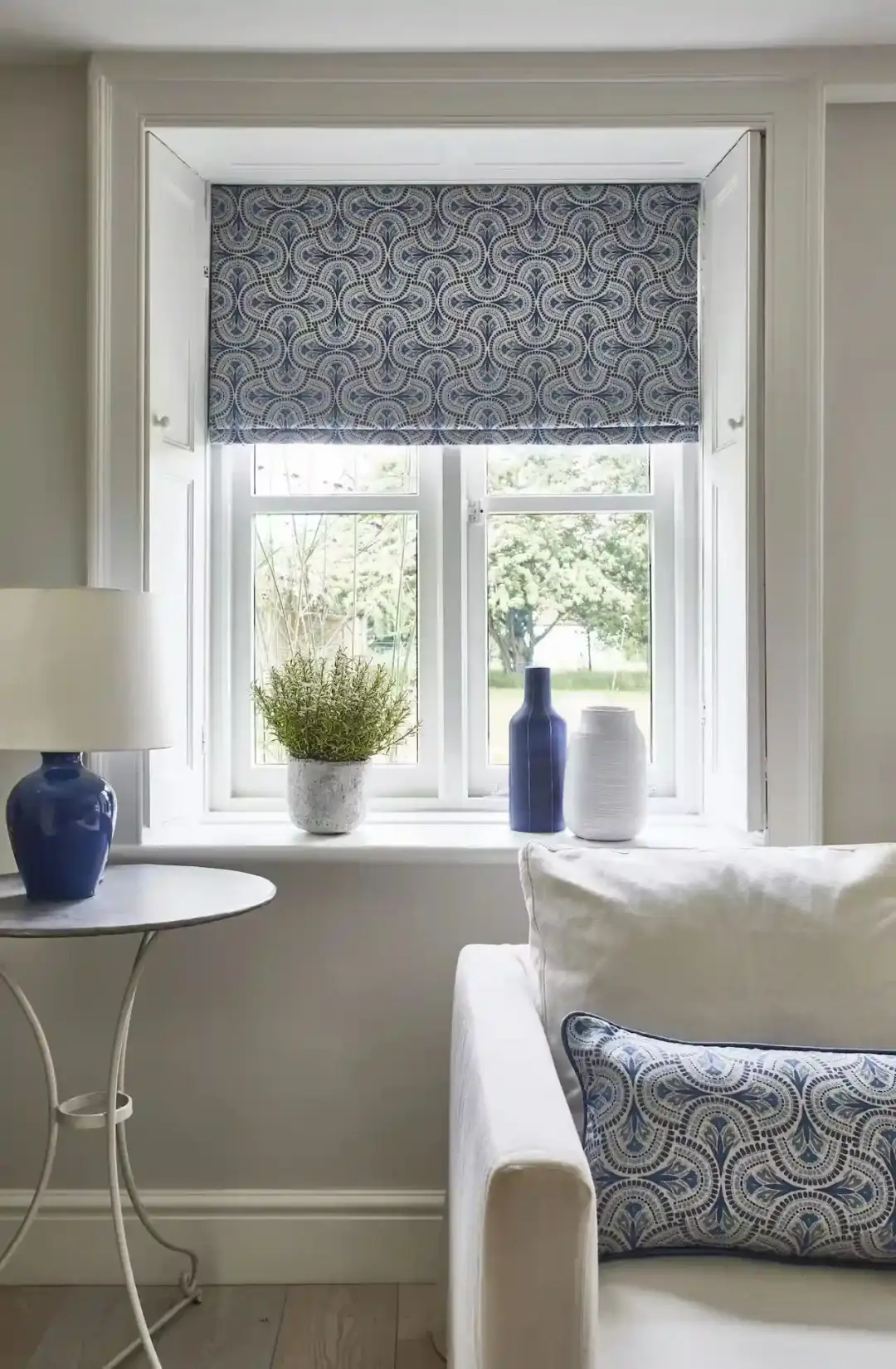 Patterned Roman blind at a white framed window