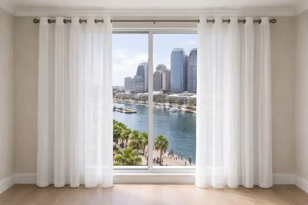 Eyelet curtain beside a city-view window