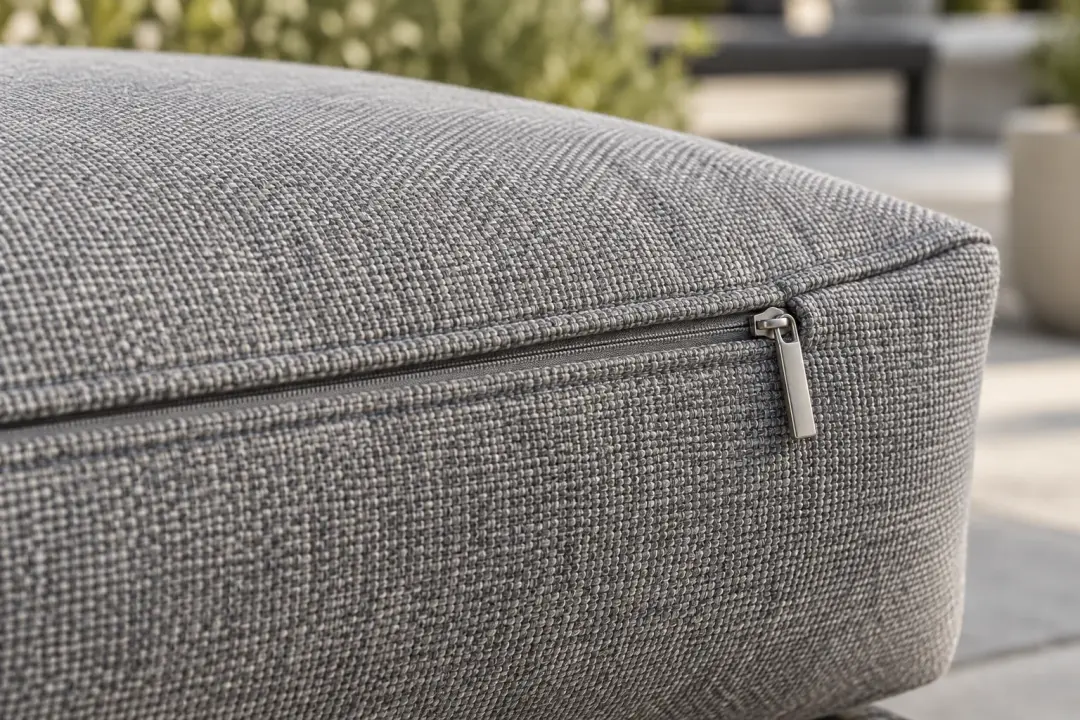 Close-up of a seam and concealed zip on a woven grey outdoor cushion